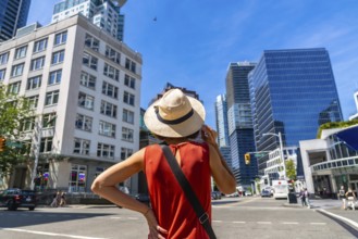 Young woman wearing a straw hat enjoying the cityscape of vancouver, british columbia, on a vibrant