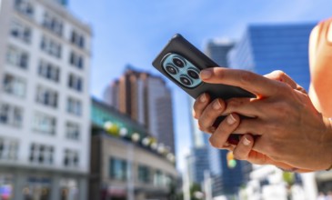Close up of hands holding smartphone with multiple camera lenses, using navigation app in vancouver