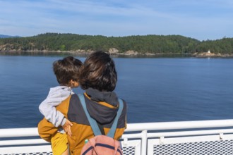 Mother and child enjoying the scenic ocean view from a ferry deck on the journey from victoria to