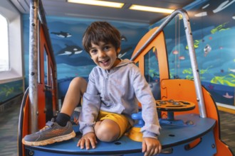 Happy child smiling and playing on a colorful play structure aboard a ferry traveling from victoria
