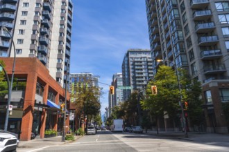 Modern residential and commercial buildings line a busy street in vancouver, british columbia, with