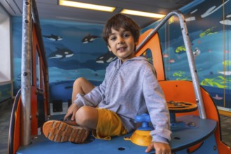 Young boy playing on a colorful play structure aboard a ferry from victoria to vancouver, with a