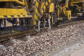 Close-up of technical devices working on train tracks, tamping machine on Hermann, Hesse, Bahn,