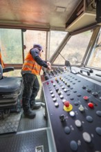 Working area in the driver's cab of a track construction vehicle with control panel, tamping