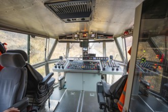 Panoramic view of the cockpit of a track construction device with various controls, tamping machine