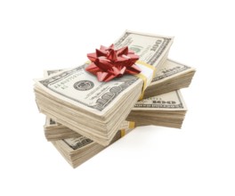 Stacks of one hundred dollar bills with red bow on top