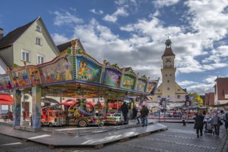 Children's carousel at the town festival on the market square, in the back the town hall, building