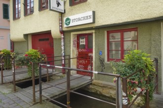 Pub, stork, traditional restaurant, beer pub on the river Ammer, red front door, graffiti, bridge,