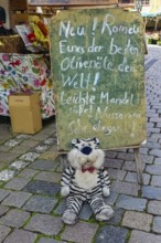 Blackboard, chalk script, funny advertisement, letters, market scene, stuffed tiger, plush toy with