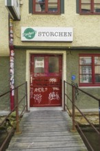 Pub, stork, traditional restaurant, beer pub on the river Ammer, red front door, graffiti, bridge,