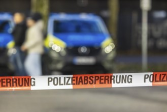 Flutter tape with the inscription police barrier. Behind it, a police car. Stuttgart,
