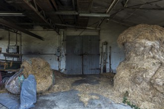 Building with wooden gate and straw bales dilapidated plant of a former agricultural production