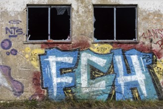 Grafity on an old wall, dilapidated plant of a former agricultural production cooperative of the