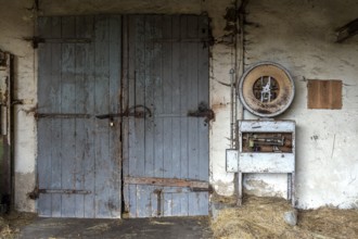 Building with wooden gate and old scale, dilapidated plant of a former agricultural production