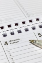 Calendar detail with ballpoint pen on a February-Wednesday page, appointment calendar