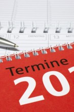 Red calendar with silver pen and spiral binding, diary