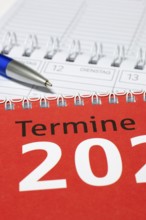 Vertical photographed calendar with blue pen and red cover, diary