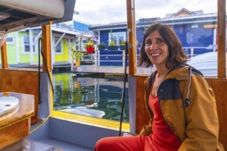 Happy tourist smiling while enjoying a sunny summer day on a small boat trip visiting the colorful