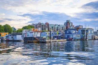 Colorful floating homes reflecting in the calm waters of fisherman's wharf park in victoria,