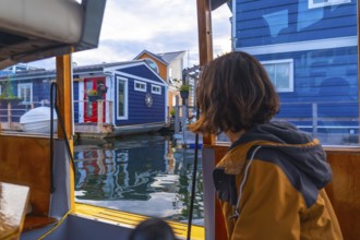 Tourist enjoying a boat tour passing by the colorful floating houses of fisherman's wharf park in