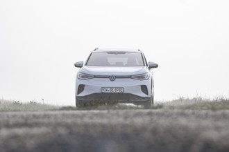 A white car from the front in a foggy, open environment, VW ID4 electric car, Deer Carsharing,