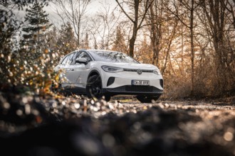 Car in an autumn forest landscape with bare trees, VW ID4 electric car, Deer Carsharing, Calw,