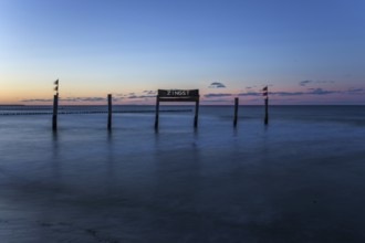 Wooden sign in the sea with inscription Zingst, long exposure, evening light, Zingst,