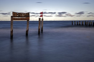 Wooden sign in the sea with inscription Zingst and Buhnen, long exposure, evening light, Zingst,