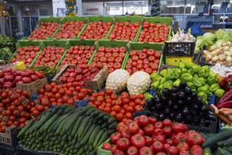 A large market stand full of tomatoes and fresh vegetables in green boxes, Akhaltsikhe market,