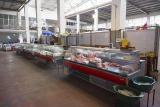 A large market hall with several refrigerated display cases full of meat, Akhaltsikhe market,