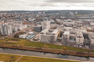 New urban development with staggered modern buildings next to a river in the foreground, Böblingen,