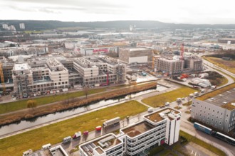 City view with modern buildings under construction along a small river in an urban area, Böblingen,
