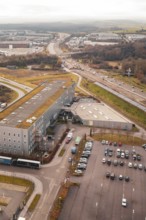View from above of an industrial area with parking spaces next to a busy motorway, Böblingen,