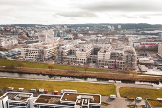 New hospital aerial view of an area with modern buildings, a river and a large construction site,