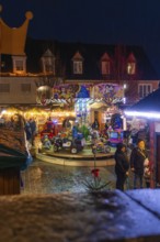 Illuminated carousel with people on a Christmas playground at night, Böblingen Christmas market,