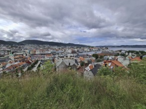 Panoramic view of Bergen city with hills in the background under a cloudy sky, Bergen Norway
