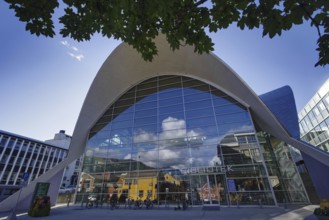 Modern glass architecture under a bright sky showing the entrance of a library in an urban setting,