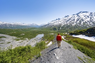Hikers on glacial moraine, view of the vast Tsina River valley with mountains, Worthington Glacier