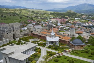 View of a castle with gardens surrounded by an urban landscape and hills in the background, Rabati