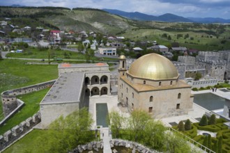 Golden dome mosque surrounded by green countryside and a small village, Rabati Fortress,