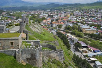 Panorama of a city with historic castle ruins on a hill under cloudy sky, Rabati Fortress,