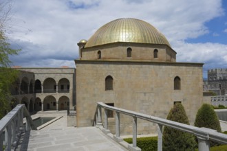 Historic building with golden dome and surrounding gardens under blue skies, Rabati Fortress,