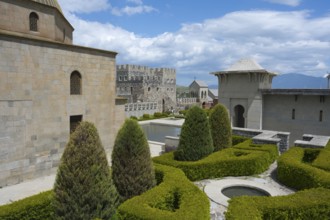 Medieval garden complex with hedges and towers against a clear, slightly cloudy sky, Rabati
