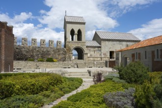 Historic church building with bell tower and adjoining garden under blue sky, Rabati Fortress,