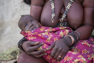 Himba woman with baby, traditional Himba village, Kaokoveld, Kunene, Namibia