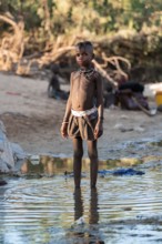 Himba child washing with water on a river, traditional Himba, Kaokoveld, Kunene, Namibia