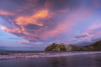 Castlepoint Beach, ocean and lighthouse on a rock, evening, sunset, dramatic sky. Castlepoint,
