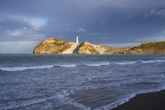 Castlepoint Beach, ocean and lighthouse on a rock, in the evening. Castlepoint, Wairarapa Coast,