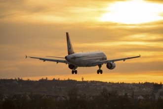 Airplane landing at sunset, orange light on horizon, Stuttgart airport, Leinfelden-Echterdingen,