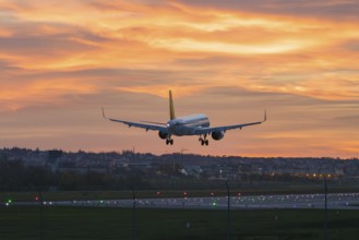 Airplane approaching urban landscape at bright sunset, Stuttgart Airport, Leinfelden-Echterdingen,